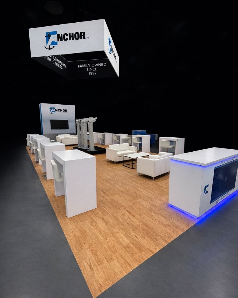 Anchor branded trade show booth with meeting area and overhead signage by Local Exhibits