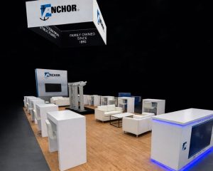 Anchor branded trade show booth with lounge seating and overhead signage by Local Exhibits