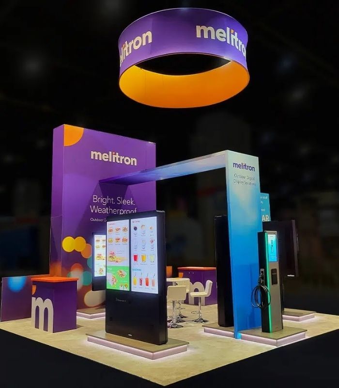 Custom trade show booth with illuminated displays and circular hanging banner by Local Exhibits