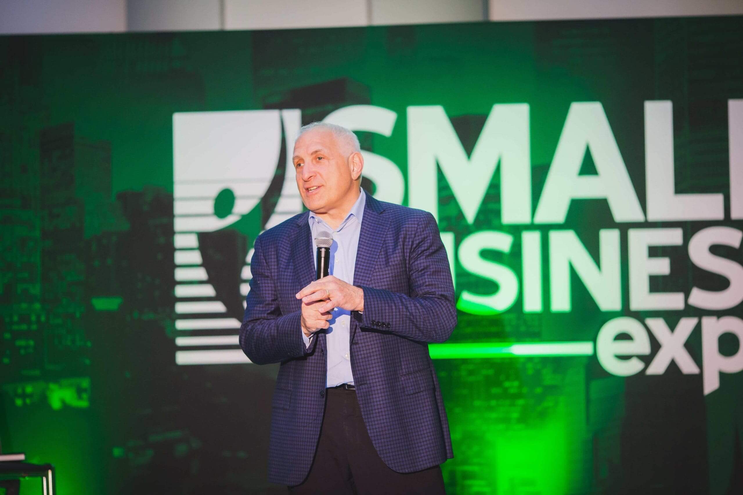 Speaker presenting on stage at Small Business Expo event by Local Exhibits