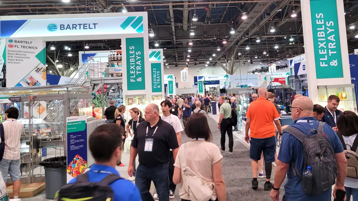PACK EXPO exhibit aisle with Bartelt booth, flexible trays displays, packaging equipment, and attendees walking the show floor