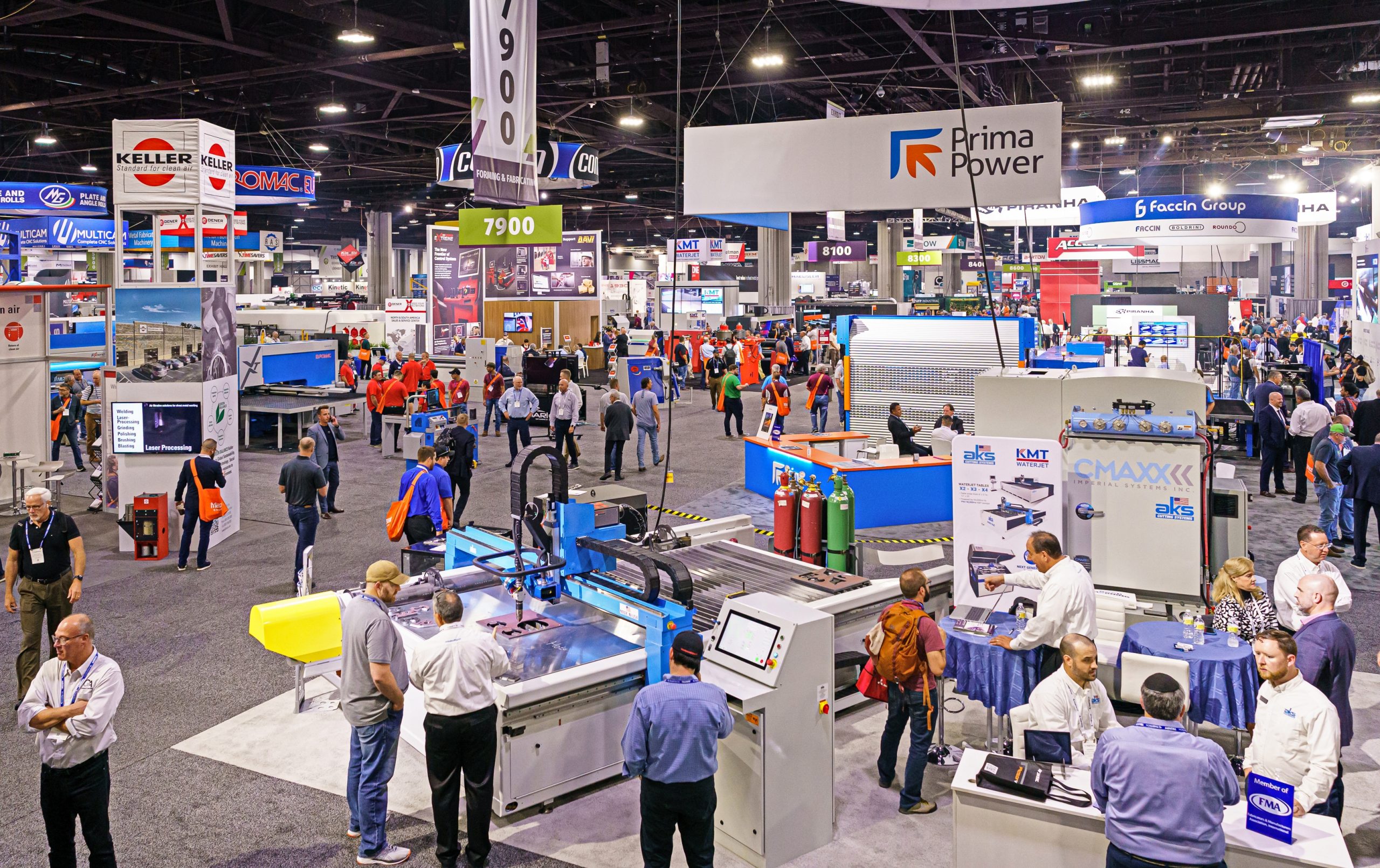 FABTECH trade show floor with machinery exhibits, branded booths, and attendees exploring industrial displays