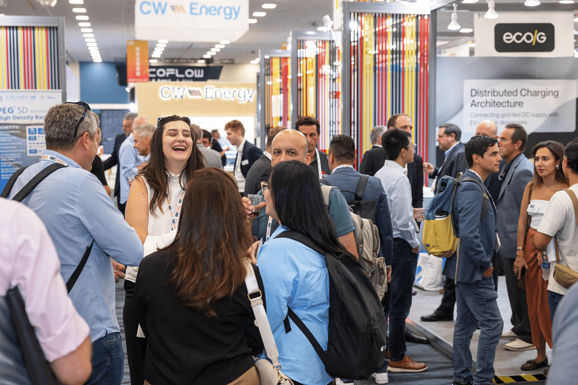 Networking and conversations among attendees at a trade show booth with CW Energy branding, showcasing energy solutions and technology.