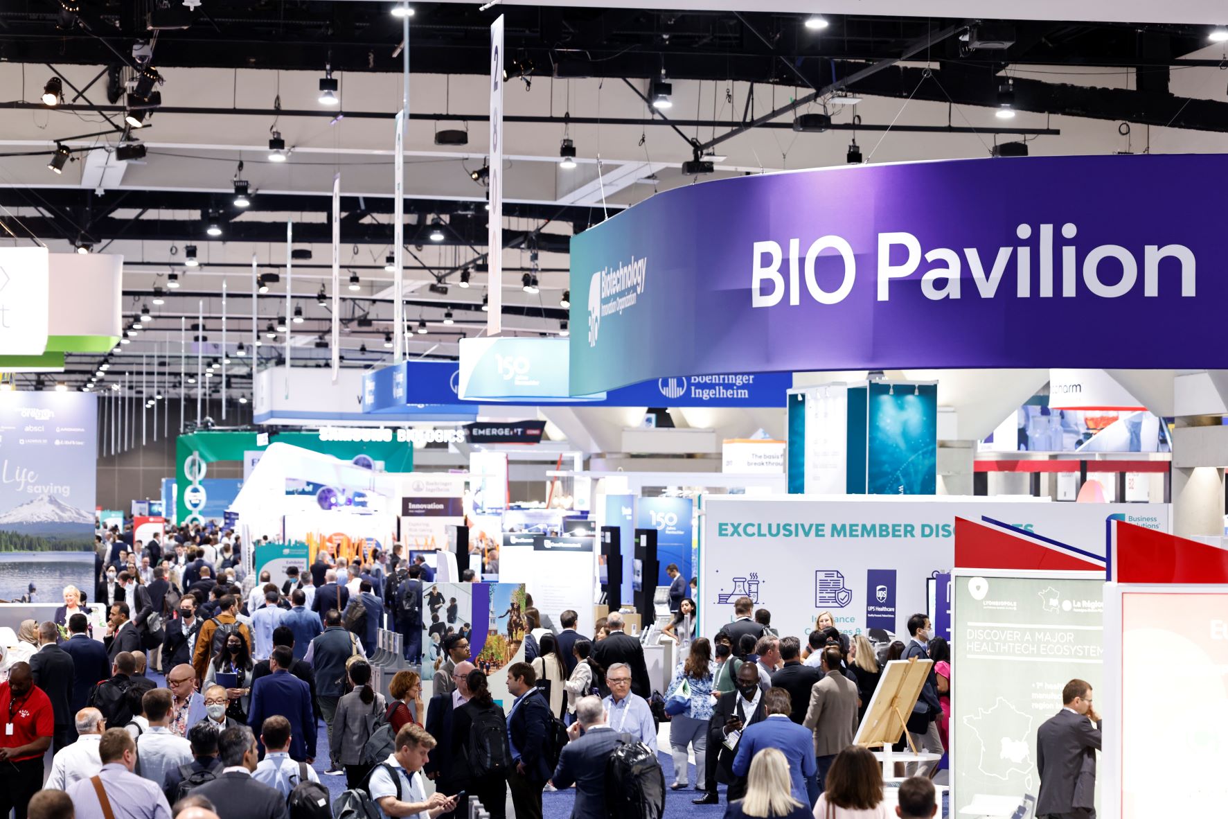 Crowd of attendees walking through the Bio Pavilion at the Bio International Convention, with booths and displays showcasing health and biotechnology companies.