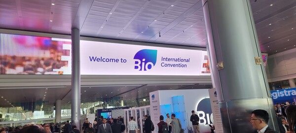 "Welcome to Bio International Convention" sign displayed at the entrance with attendees gathered in the lobby area.