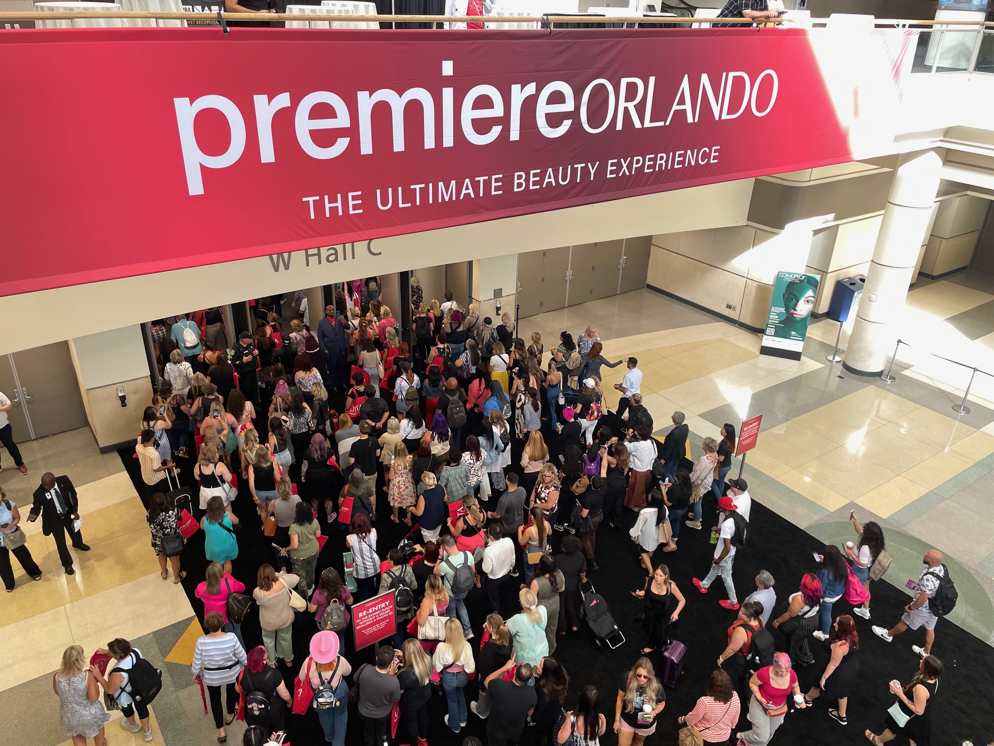 Crowd gathering at the entrance of the Premiere Orlando Beauty Show with large event signage and attendees lined up for entry.